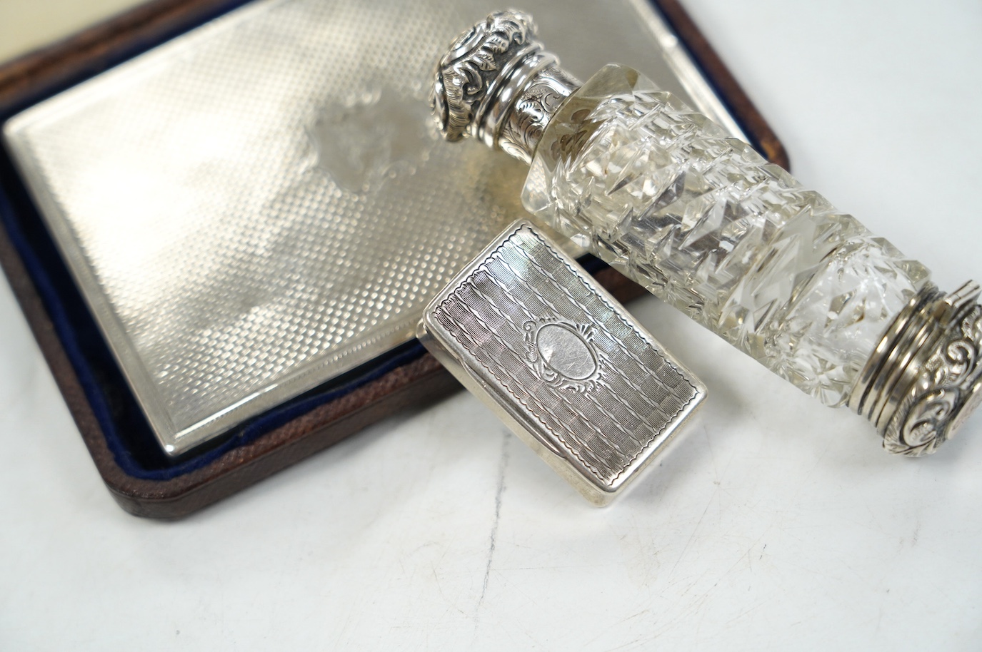 A Victorian silver mounted card purse, by Frederick Marson, Birmingham, 1859, 97mm, in a fitted case, together with a white metal vinaigrette and a white metal mounted cut glass double ended scent bottle, one end with a